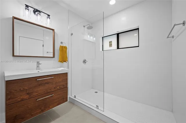 a bathroom with a shower sink and mirror