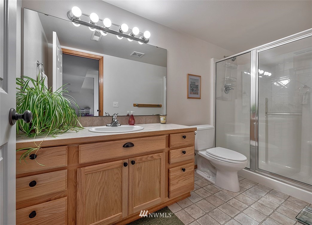 17029 4th Avenue Southeast Bothell, WA 98012 - Photo 11 of 23 a bathroom with a double vanity sink a toilet a mirror and shower