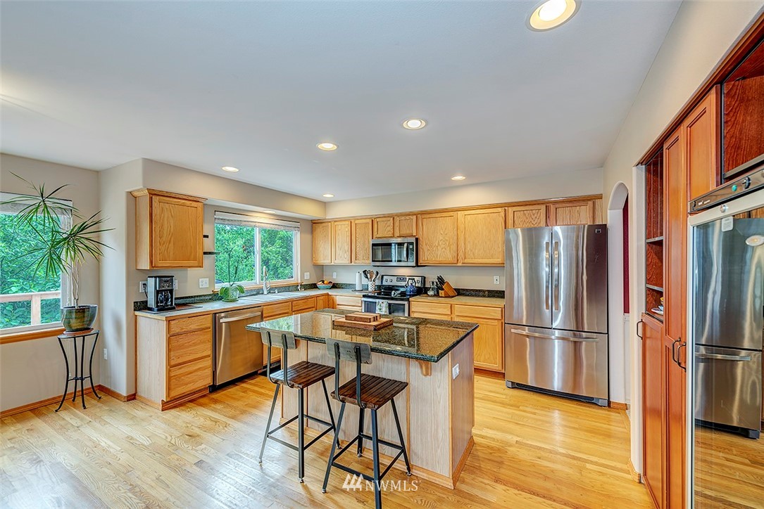 17029 4th Avenue Southeast Bothell, WA 98012 - Photo 6 of 23 a kitchen with stainless steel appliances granite countertop a refrigerator a stove and a wooden floors