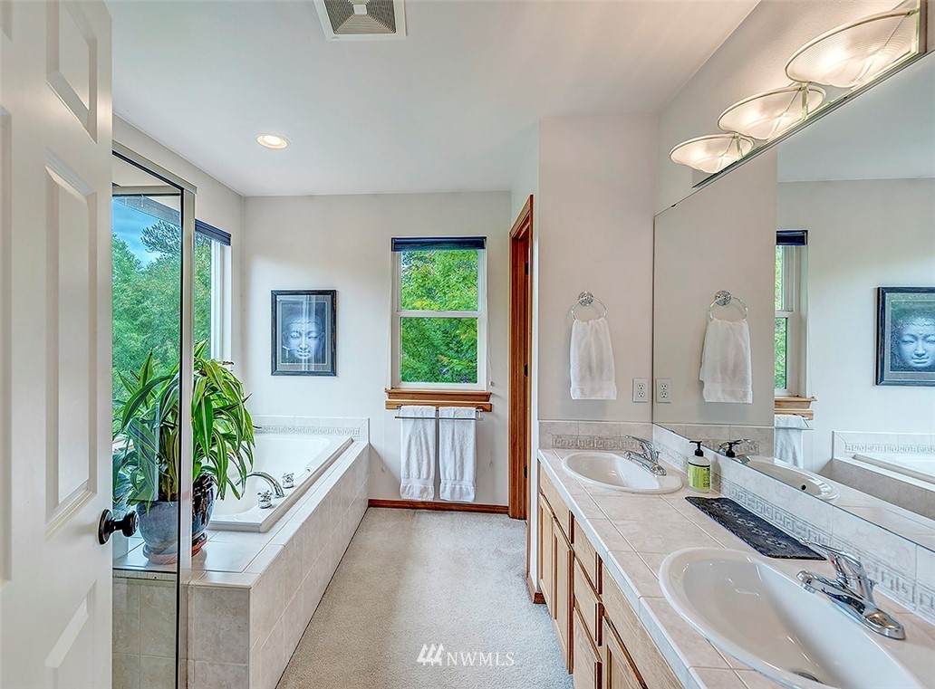 17029 4th Avenue Southeast Bothell, WA 98012 - Photo 9 of 23 a spacious bathroom with a double vanity sink a large mirror and a bathtub