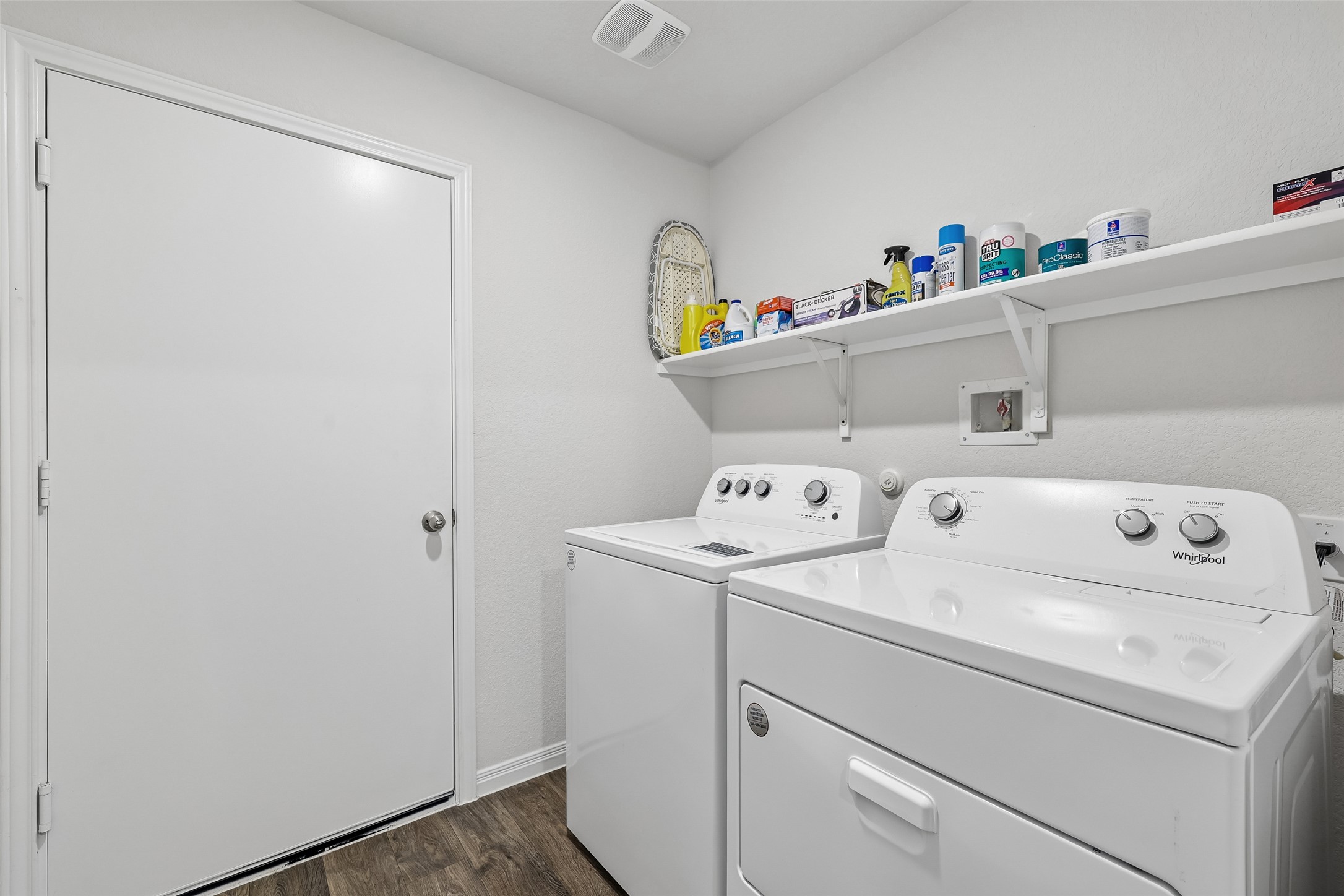 19805 Abigail Fillmore Road Manor, TX 78653 - Photo 27 of 40 Functional laundry space featuring a practical shelf for storage and wood flooring.