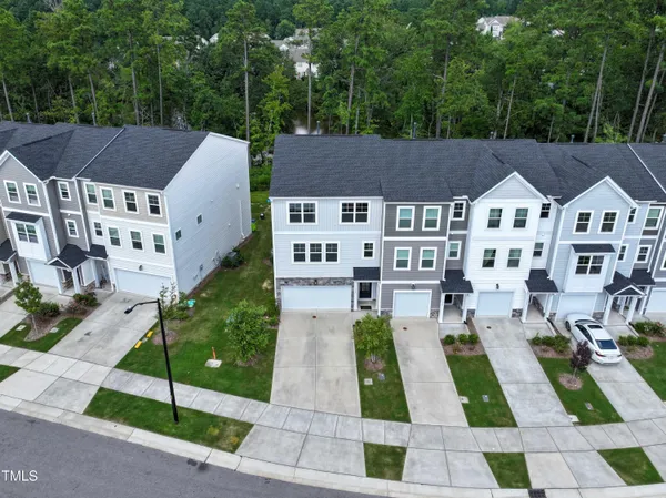an aerial view of a house with a garden and lake view