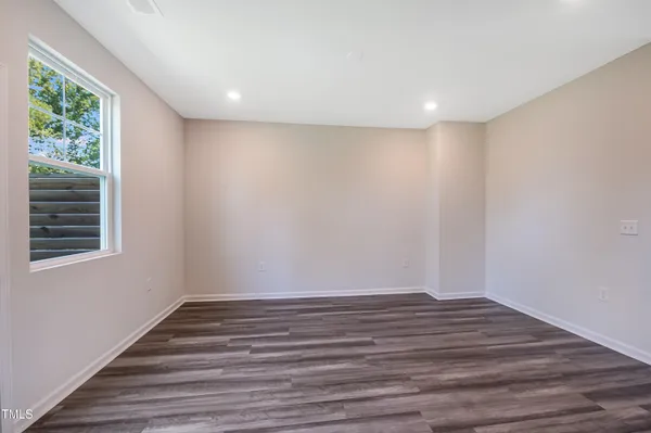 a view of room with window and wooden floor
