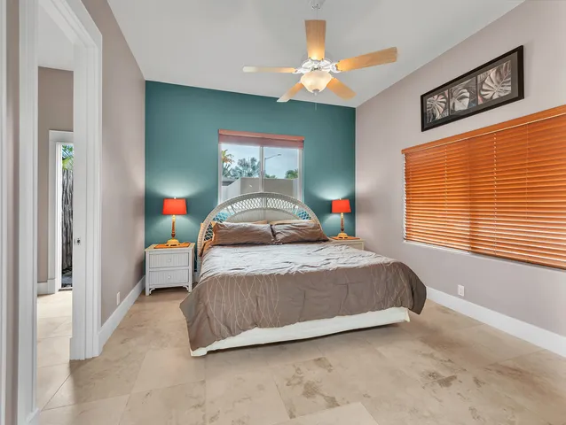 a bedroom with a bed a window and a chandelier