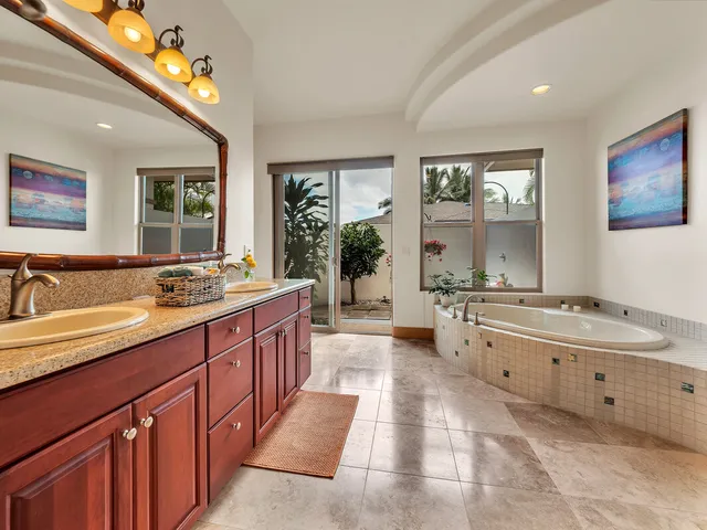 a large spacious bathroom with a tub double sink and a large mirror