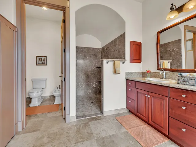a bathroom with a granite countertop sink mirror and toilet