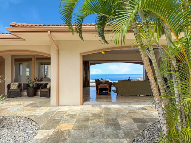 a view of a house with a patio and a yard