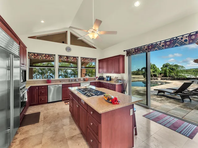 a kitchen with stainless steel appliances kitchen island granite countertop a stove a refrigerator and a view of living room