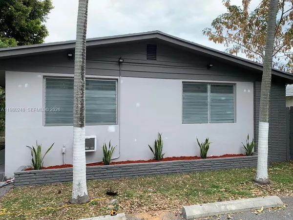 a front view of a house with lots of potted plants