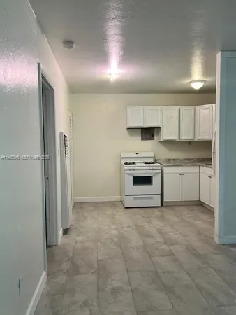 a view of kitchen with refrigerator and stove