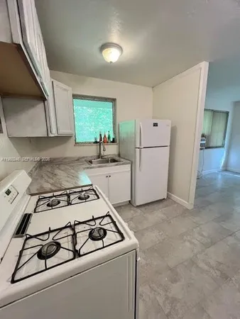 a kitchen with a stove a sink and a refrigerator