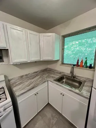 a kitchen with refrigerator a stove a sink and a microwave