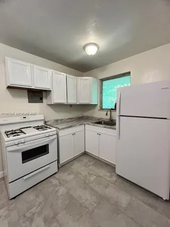 a kitchen with a stove a sink and a refrigerator
