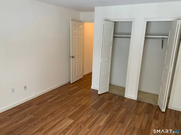 an empty room with wooden floor and closet area