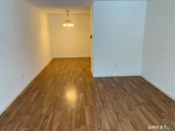 a view of a room with wooden floor and white walls
