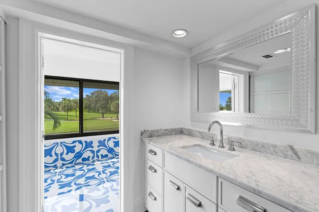 a bathroom with a large window and a potted plant