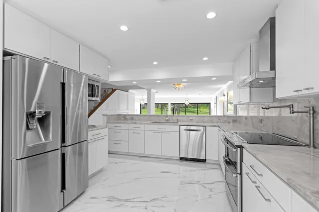 a kitchen with stainless steel appliances granite countertop a sink and cabinets