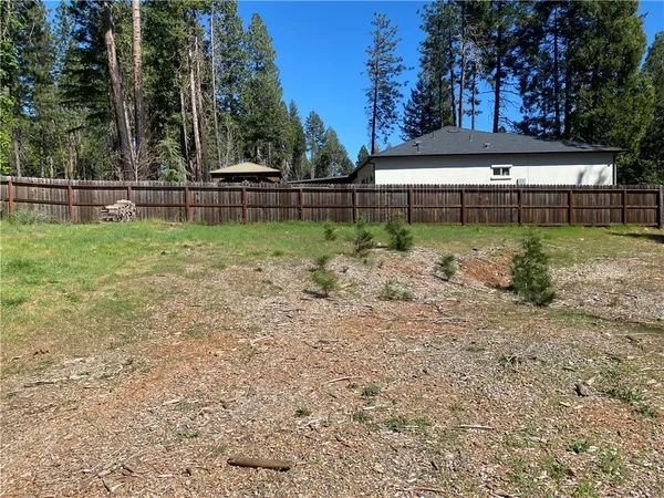 a view of backyard with wooden fence