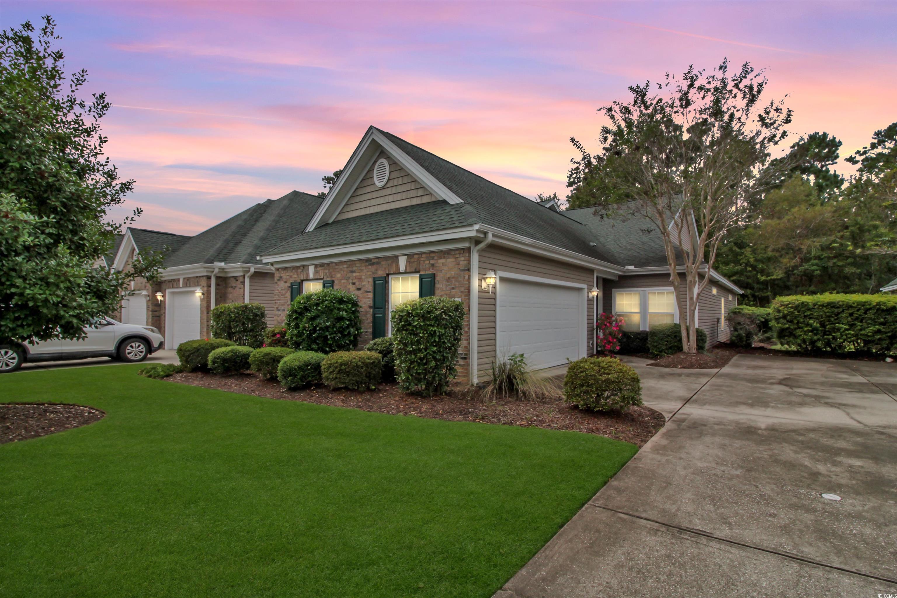 301 Nut Hatch Lane, Unit D Murrells Inlet, SC 29576 - Photo 1 of 40 Single story home with roof with shingles, brick siding, a front yard, concrete driveway, and an attached garage