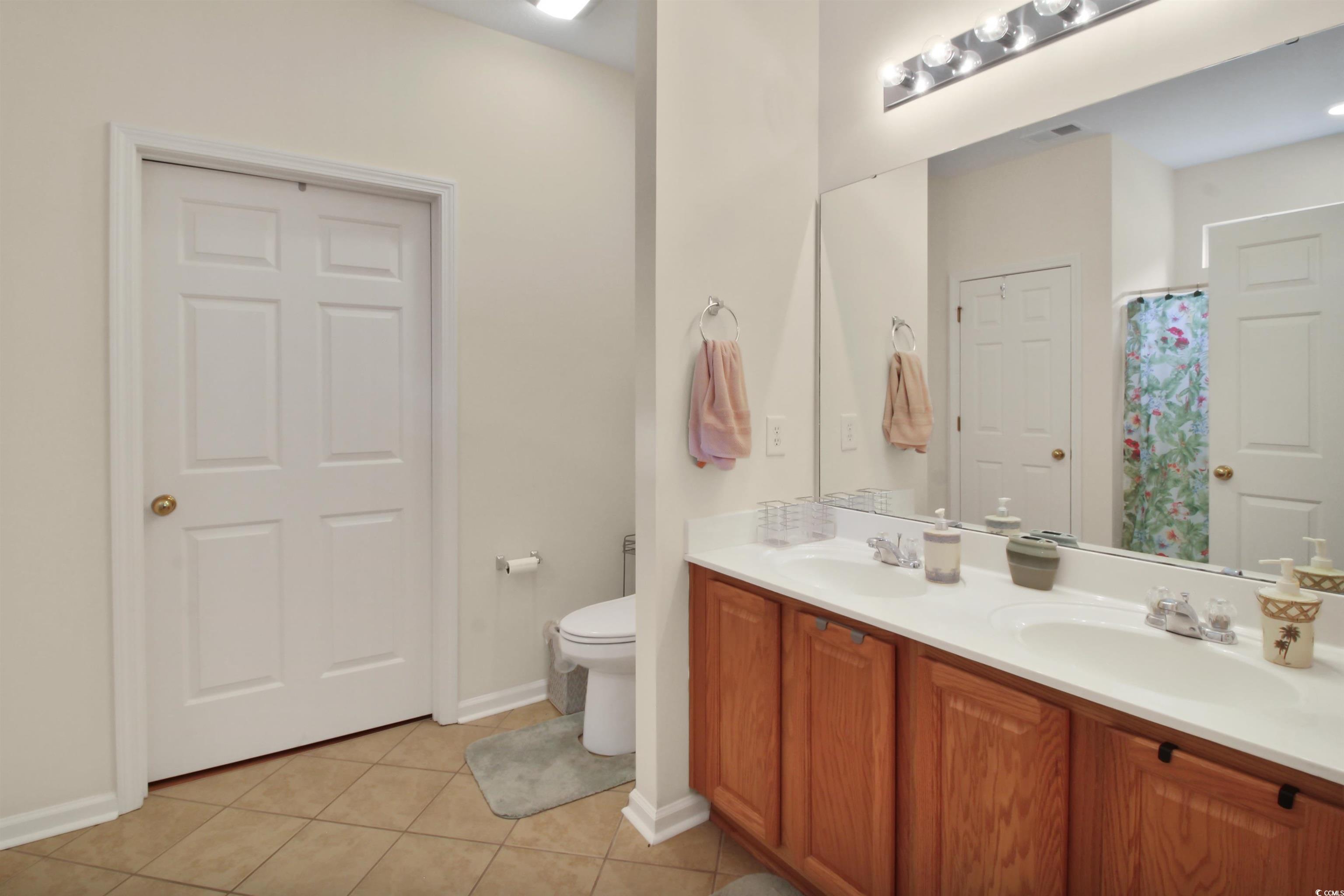 301 Nut Hatch Lane, Unit D Murrells Inlet, SC 29576 - Photo 12 of 40 Bathroom featuring light tile patterned flooring, double vanity, and a shower with shower curtain