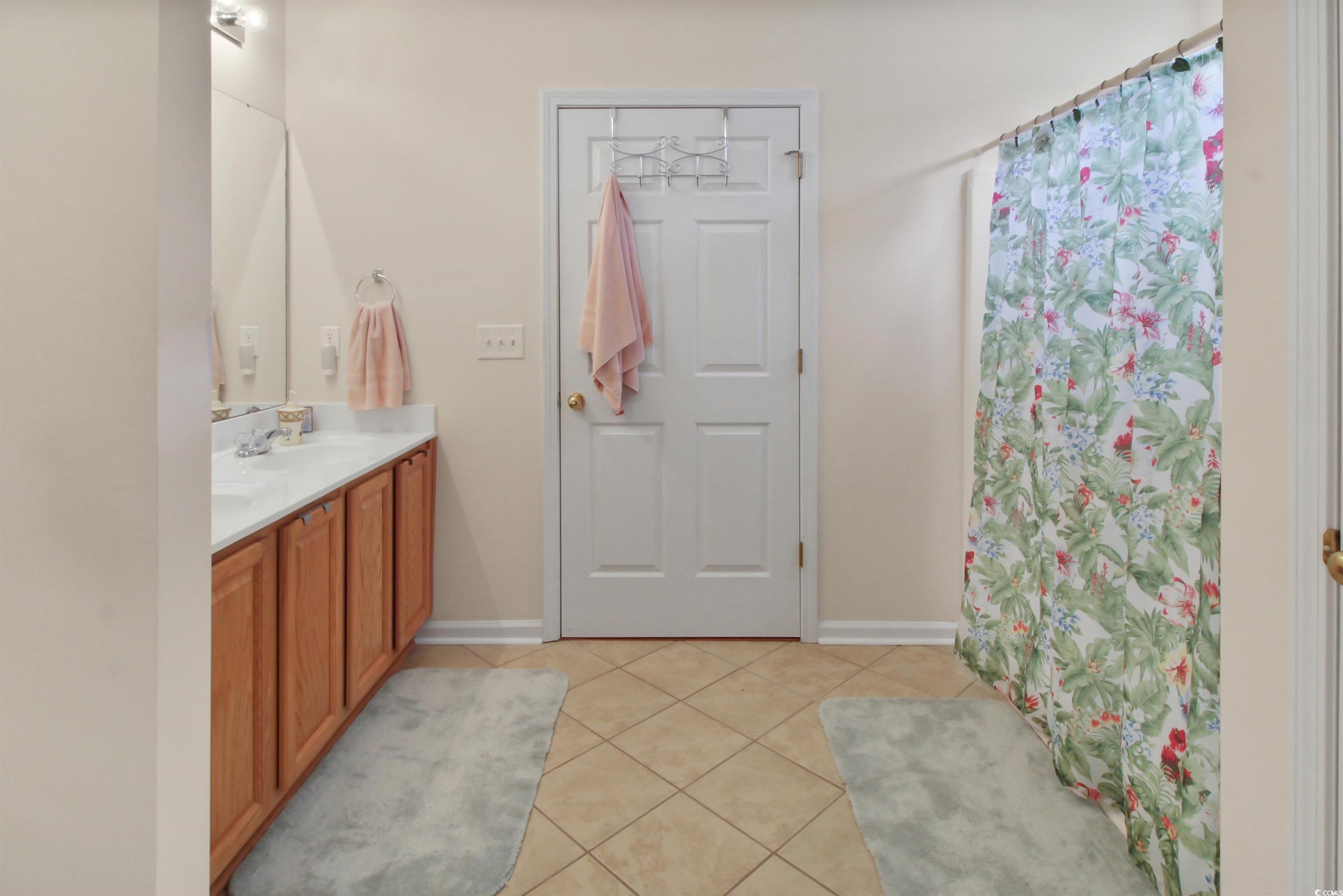 301 Nut Hatch Lane, Unit D Murrells Inlet, SC 29576 - Photo 13 of 40 Full bath with light tile patterned floors, double vanity, and a shower with curtain