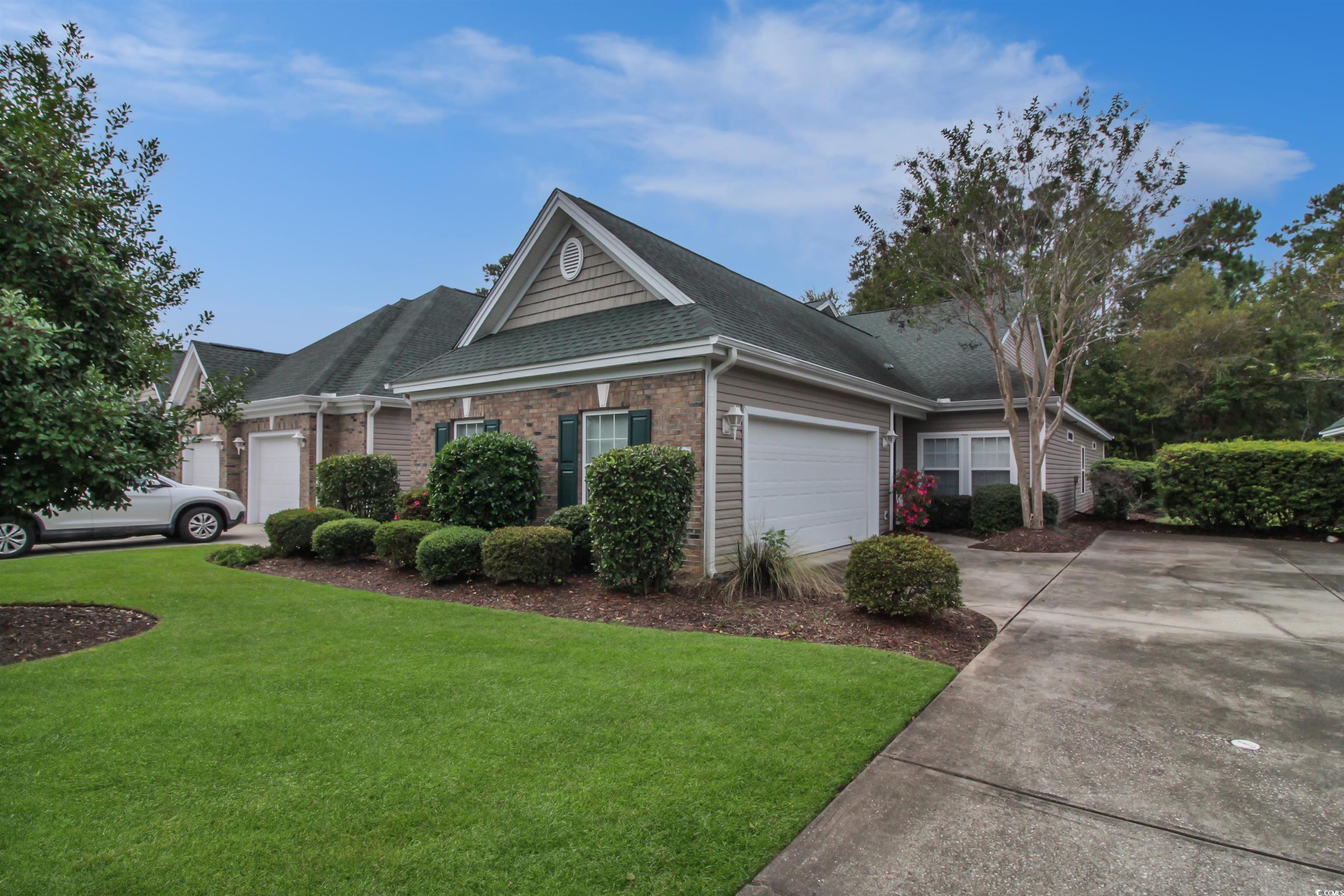 301 Nut Hatch Lane, Unit D Murrells Inlet, SC 29576 - Photo 2 of 40 Ranch-style house featuring brick siding, roof with shingles, a front lawn, and driveway