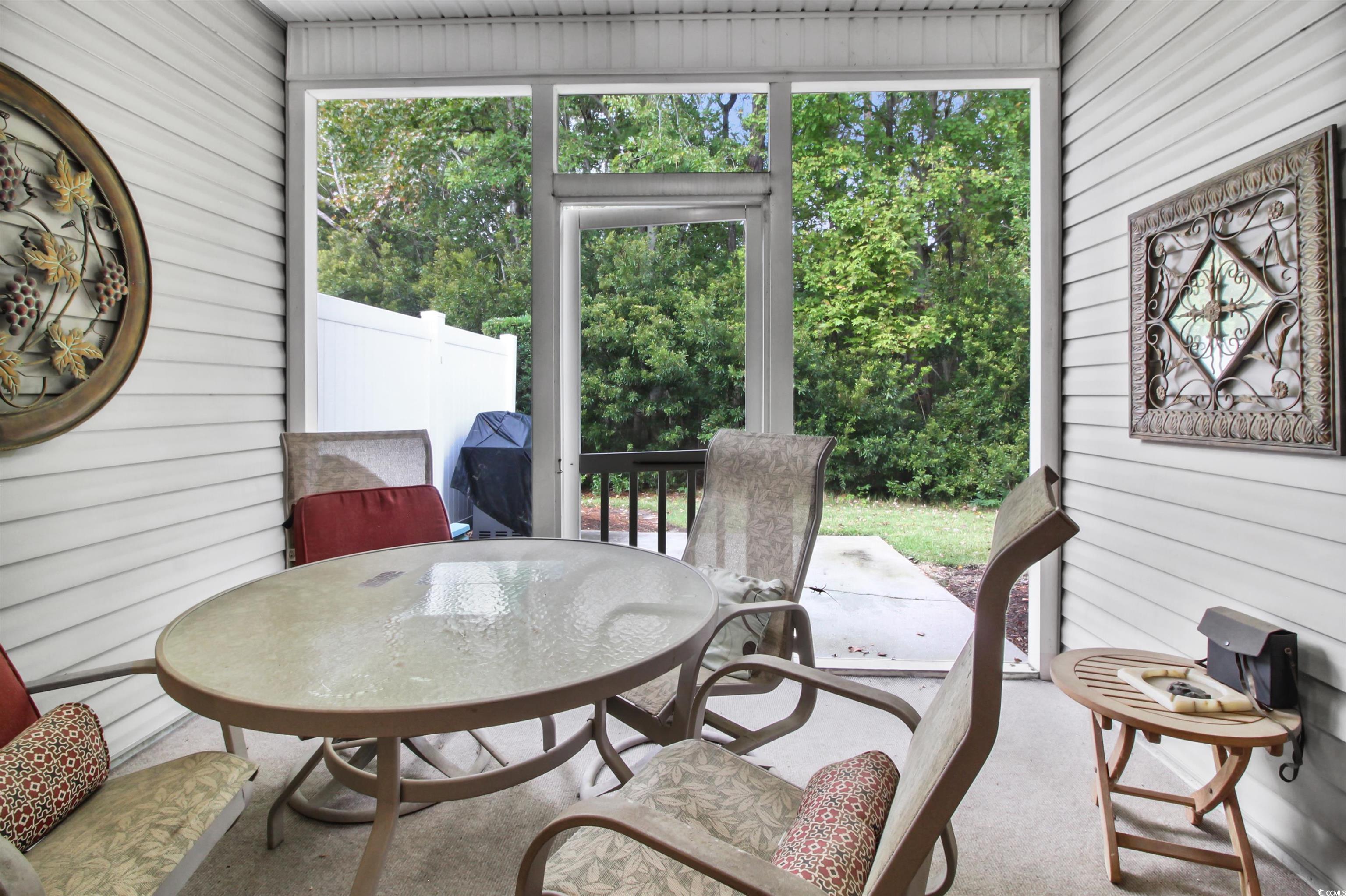 301 Nut Hatch Lane, Unit D Murrells Inlet, SC 29576 - Photo 20 of 40 Sunroom / solarium with outdoor dining area, a patio area, and view of wooded area