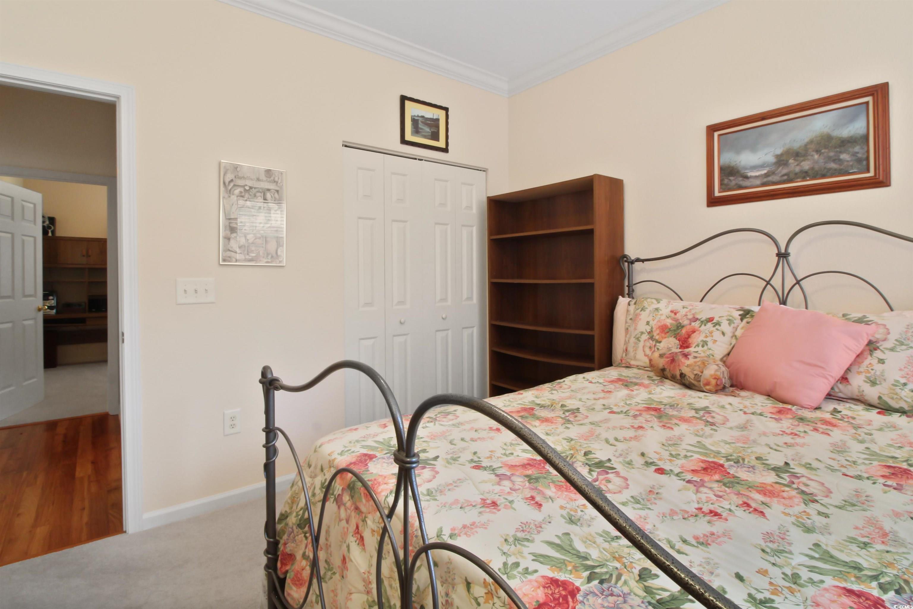 301 Nut Hatch Lane, Unit D Murrells Inlet, SC 29576 - Photo 24 of 40 Carpeted bedroom with ornamental molding, a closet, and wood finished floors