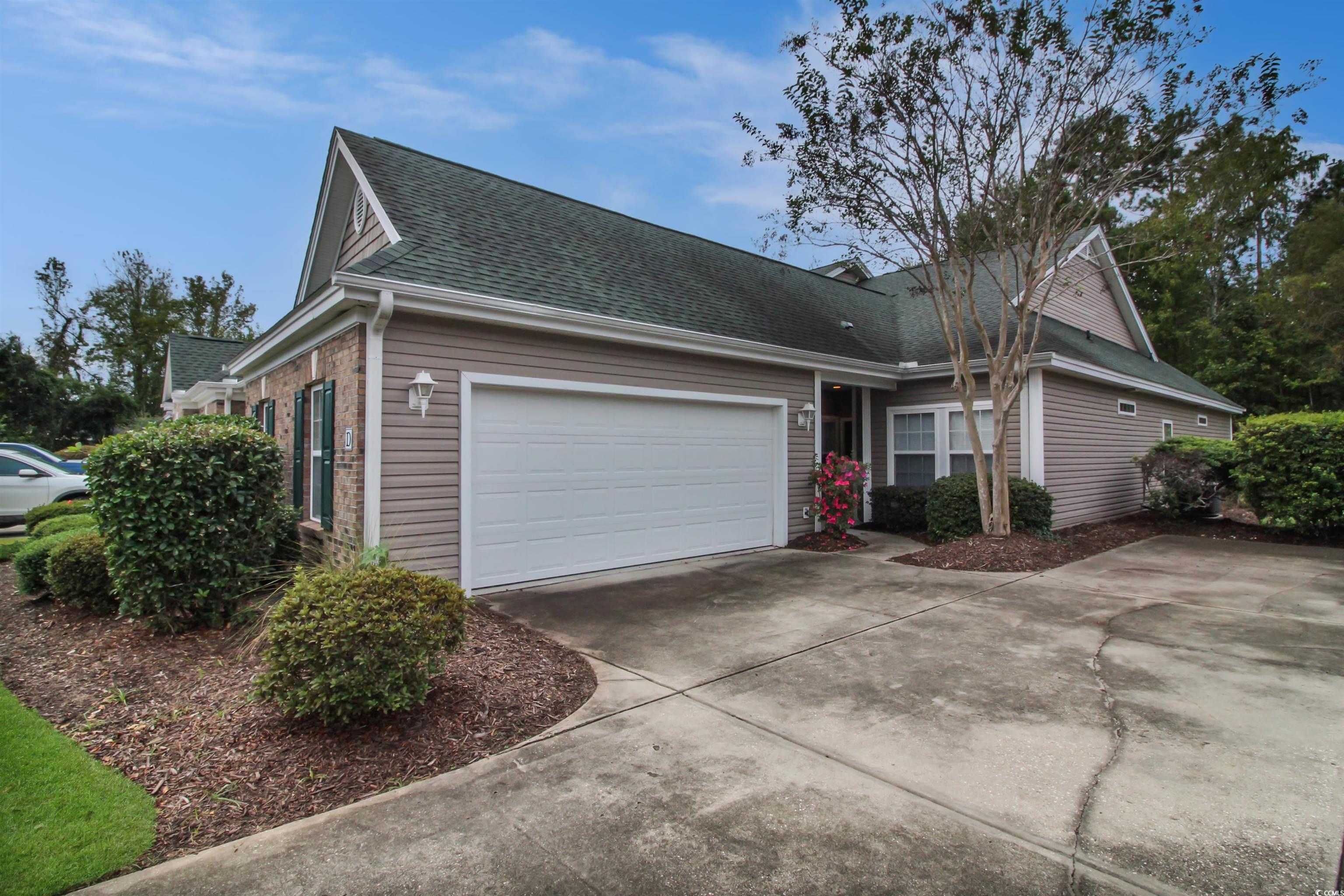 301 Nut Hatch Lane, Unit D Murrells Inlet, SC 29576 - Photo 3 of 40 View of front facade featuring driveway, a shingled roof, an attached garage, and brick siding