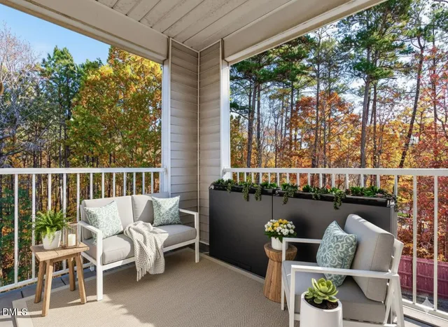 a balcony with couple of chairs and a couch