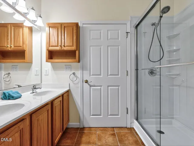 a bathroom with a granite countertop sink a mirror a vanity and shower