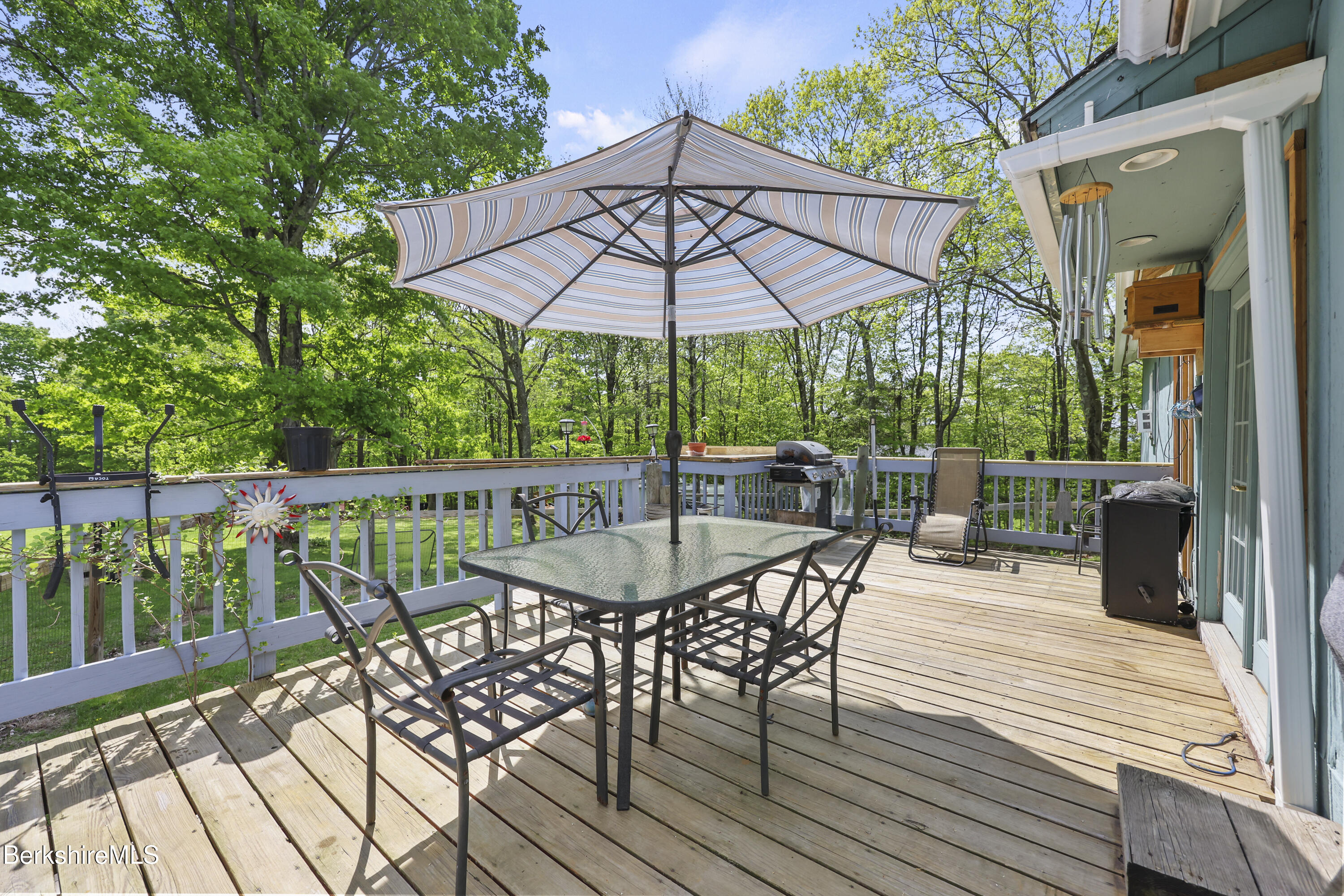 192 Curran Road Cheshire, MA 01225 - Photo 32 of 50 a patio with wooden floor a yard a table and chairs