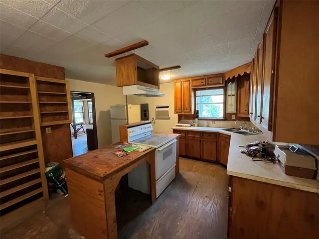 a kitchen that has a sink a stove top oven a counter space and cabinets