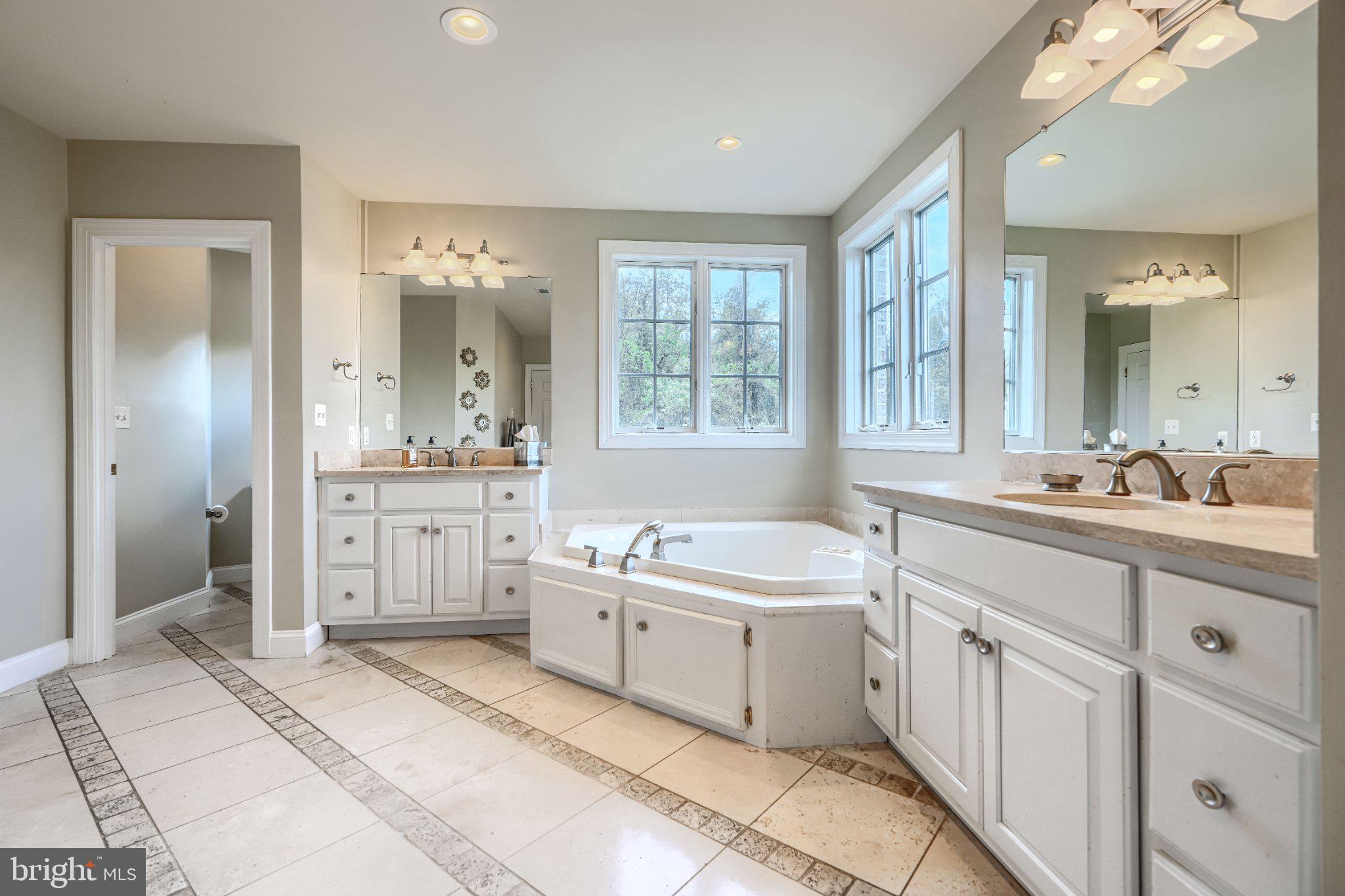 2415 Old Bosley Road Lutherville-Timonium, MD 21093 - Photo 31 of 65 a spacious bathroom with a double vanity sink a mirror and a bathtub
