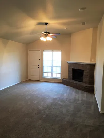 an empty room with windows and fireplace