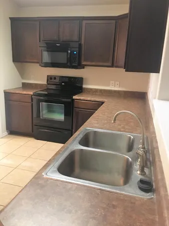 a kitchen with a sink and a stove top oven