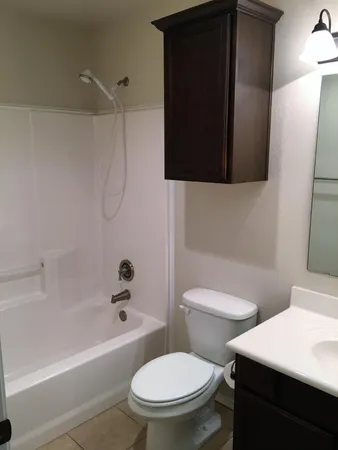 a white toilet sitting next to a bath tub