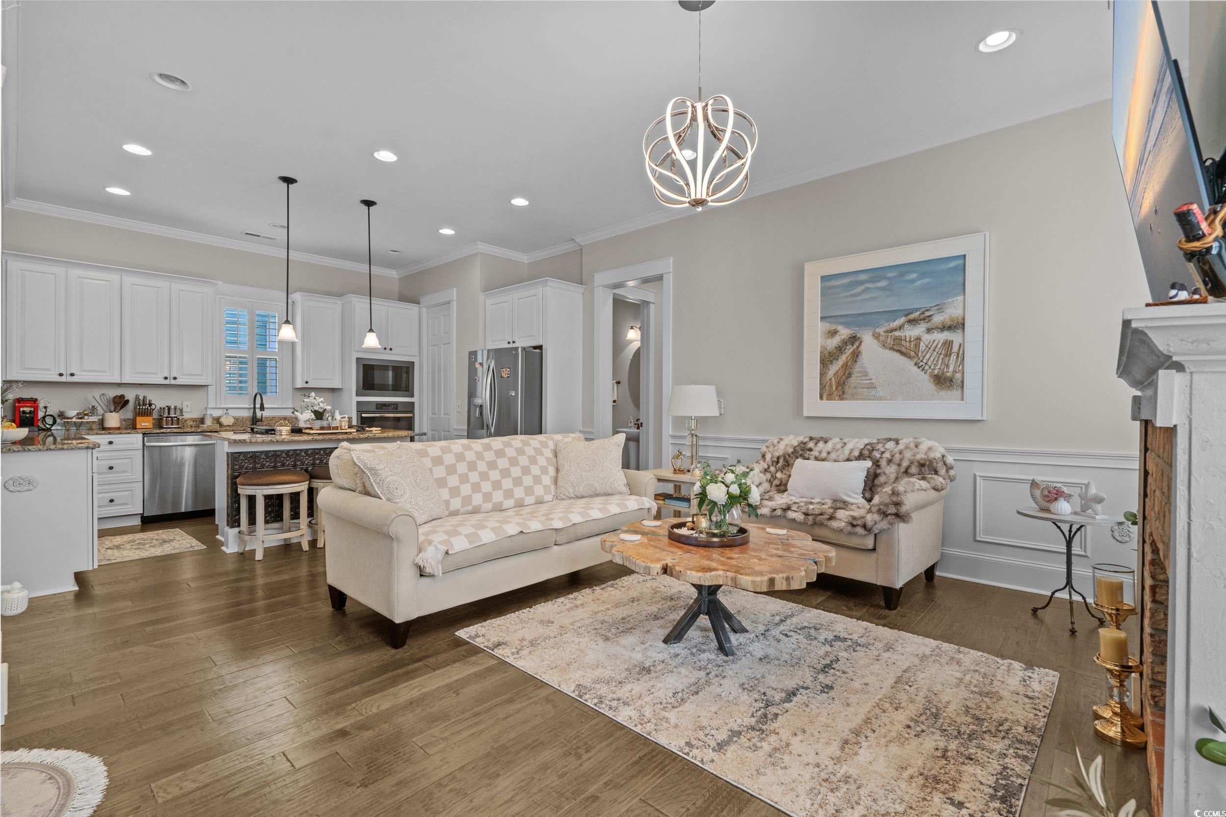 927 Iris Street Myrtle Beach, SC 29577 - Photo 13 of 40 Living room featuring dark wood finished floors, a chandelier, wainscoting, recessed lighting, and crown molding