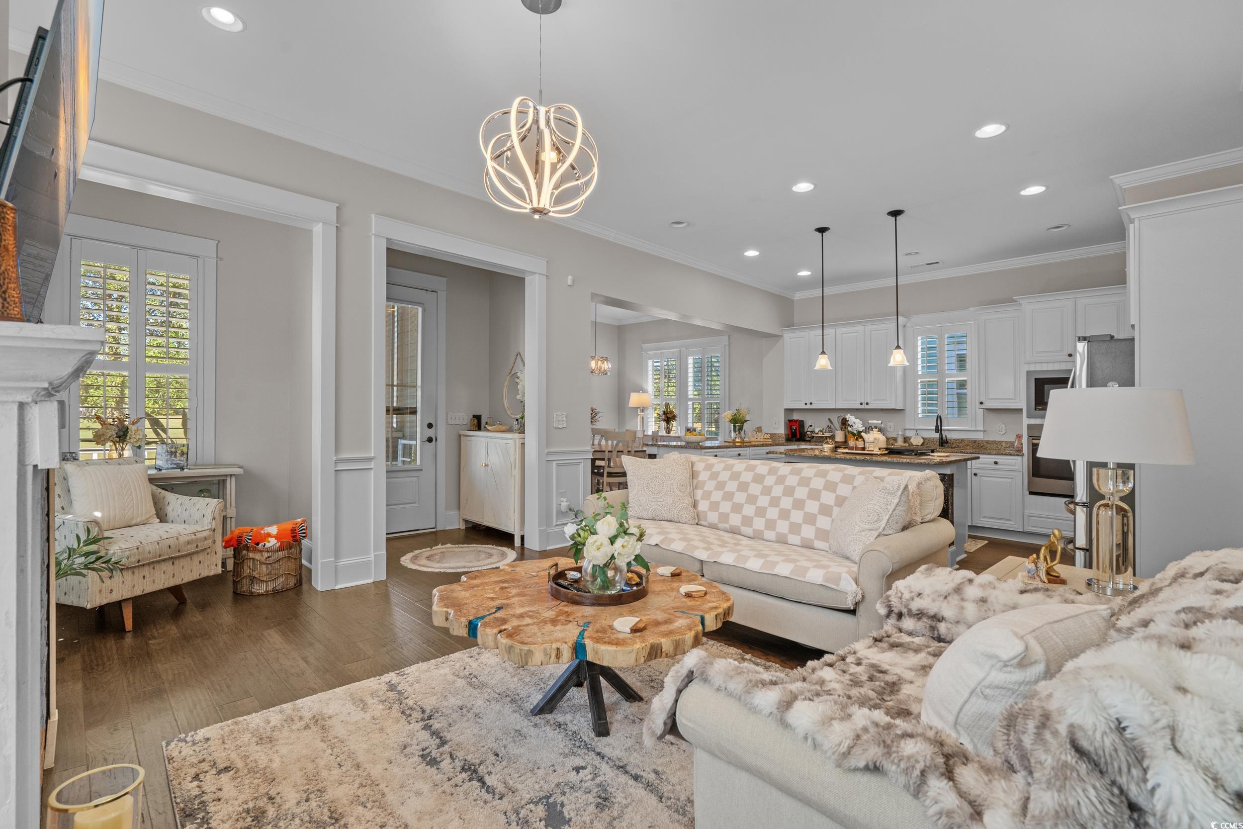927 Iris Street Myrtle Beach, SC 29577 - Photo 14 of 40 Living area featuring recessed lighting, dark wood finished floors, crown molding, a chandelier, and wainscoting