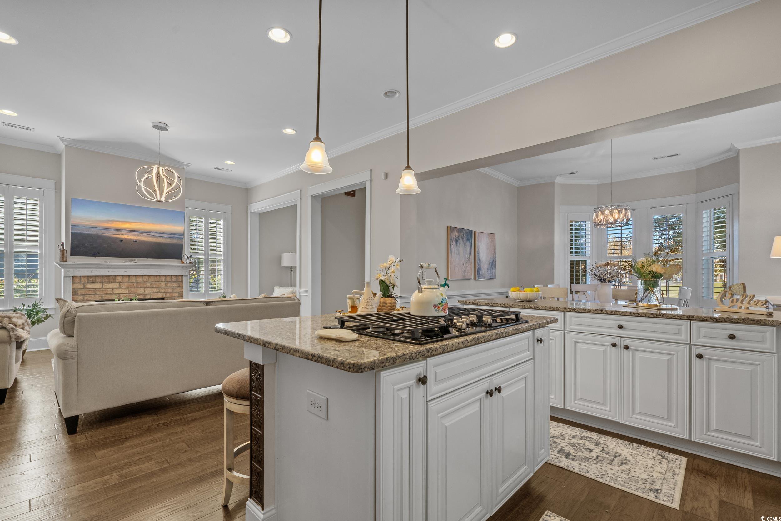 927 Iris Street Myrtle Beach, SC 29577 - Photo 40 of 40 Kitchen featuring open floor plan, white cabinets, light stone counters, pendant lighting, and crown molding