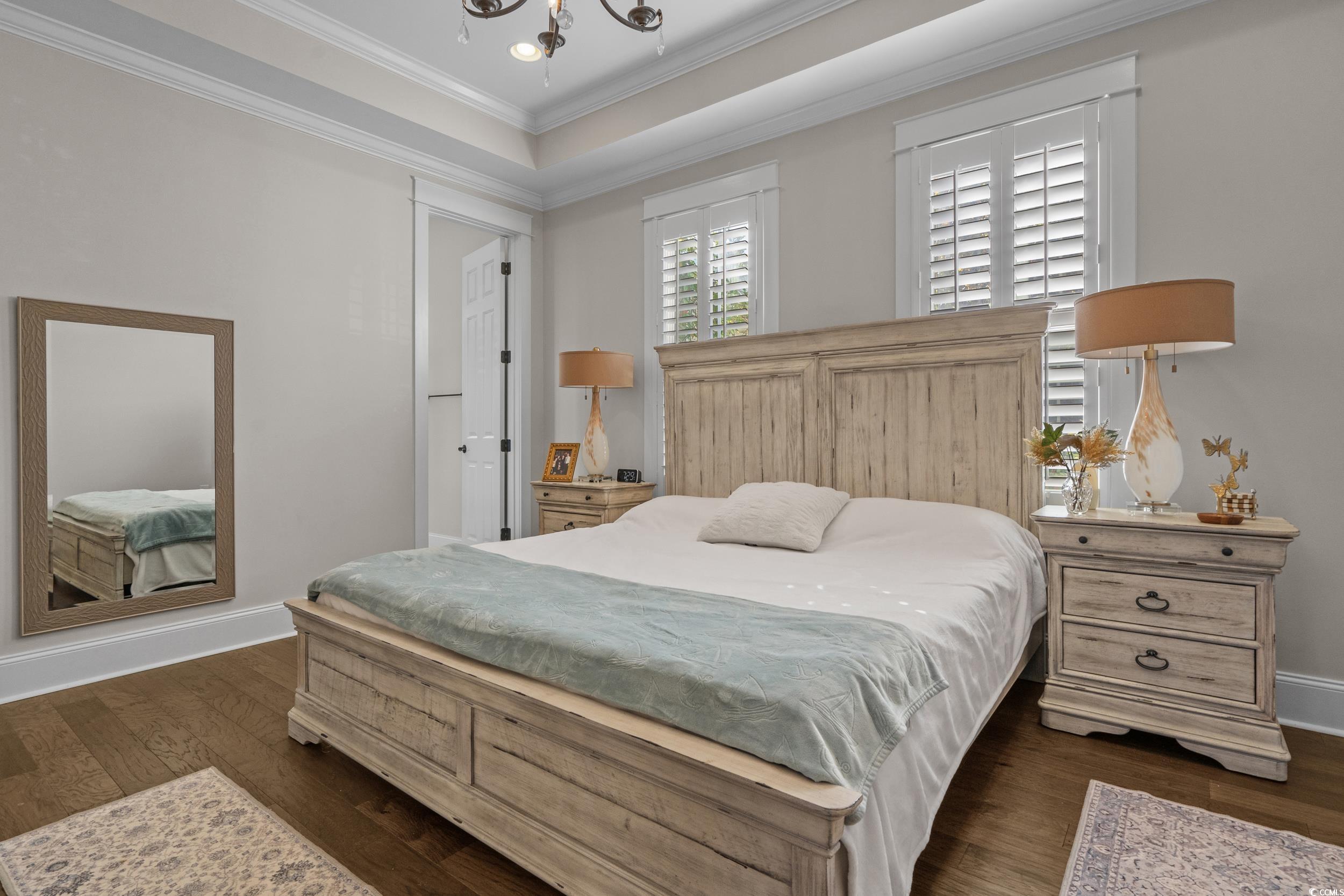 927 Iris Street Myrtle Beach, SC 29577 - Photo 25 of 40 Bedroom with ornamental molding, a raised ceiling, dark wood finished floors, a chandelier, and recessed lighting