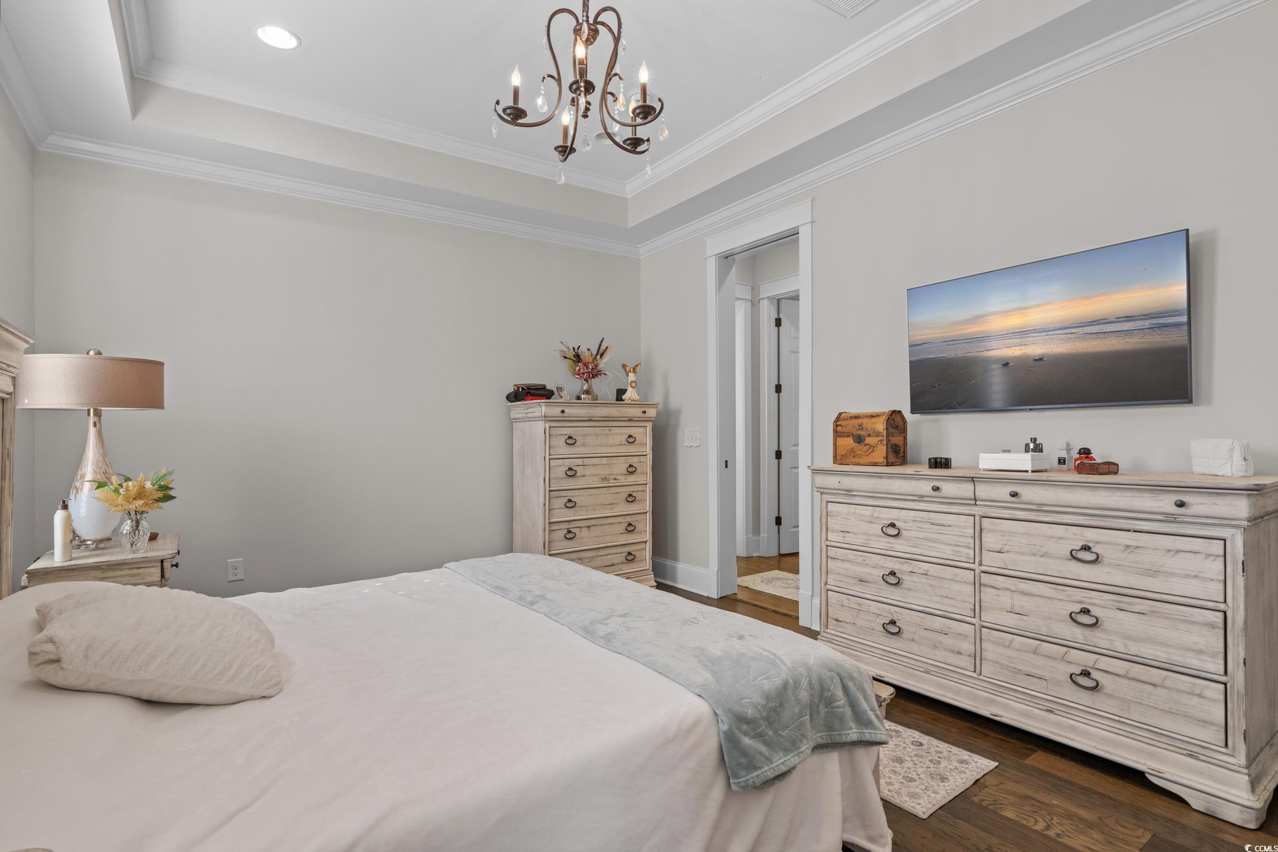 927 Iris Street Myrtle Beach, SC 29577 - Photo 26 of 40 Bedroom featuring a raised ceiling, dark wood-style flooring, crown molding, a chandelier, and recessed lighting