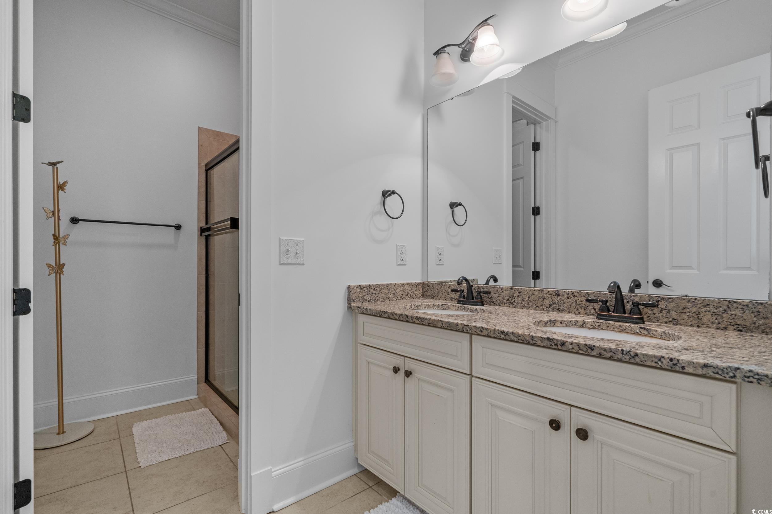 927 Iris Street Myrtle Beach, SC 29577 - Photo 31 of 40 Bathroom with ornamental molding, light tile patterned flooring, double vanity, and a stall shower