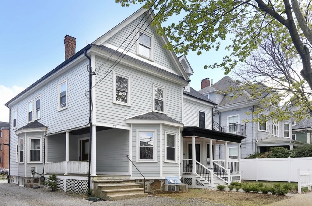 a front view of a house with a tree