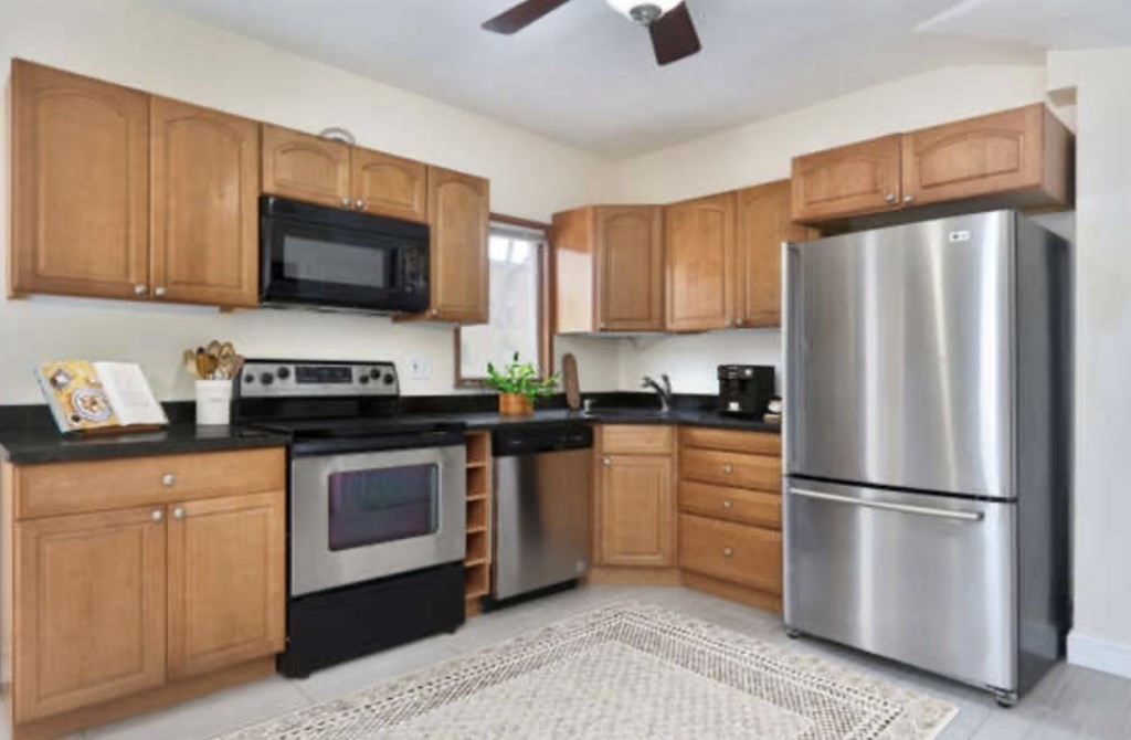 22 Winslow Road Brookline, MA 02446 - Photo 4 of 10 a kitchen with stainless steel appliances granite countertop a refrigerator stove a sink dishwasher and microwave with wooden floor