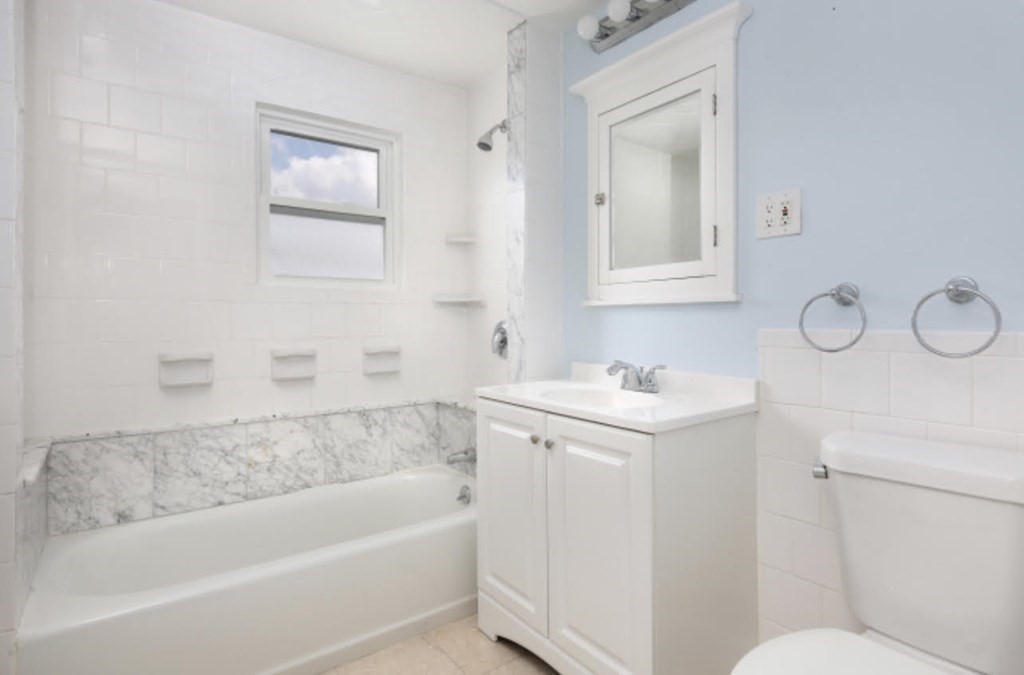 22 Winslow Road Brookline, MA 02446 - Photo 6 of 10 a bathroom with a granite countertop sink mirror vanity bathtub and a toilet