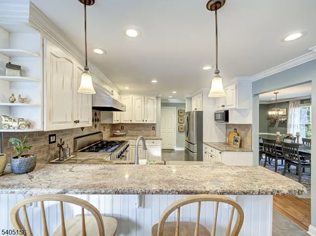 a kitchen with kitchen island granite countertop a sink a counter top space appliances and cabinets