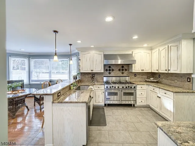 a kitchen with a stove cabinets and chairs