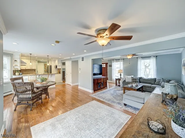 a living room with furniture kitchen view and a large window