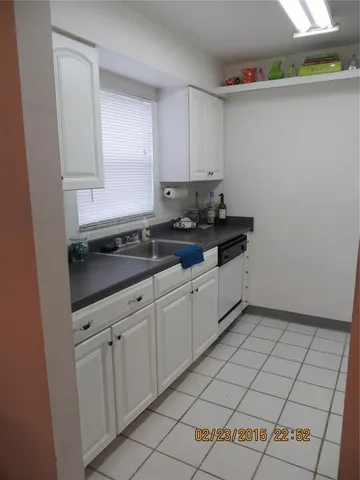 a kitchen with granite countertop white cabinets and sink